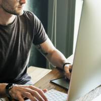 Mann arbeitet am Mac
